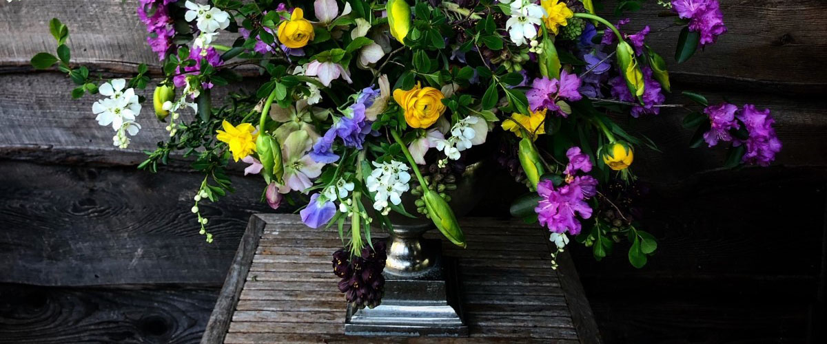 Luscious spring floral arrangement including blue, pink, purple, yellow and white flowers