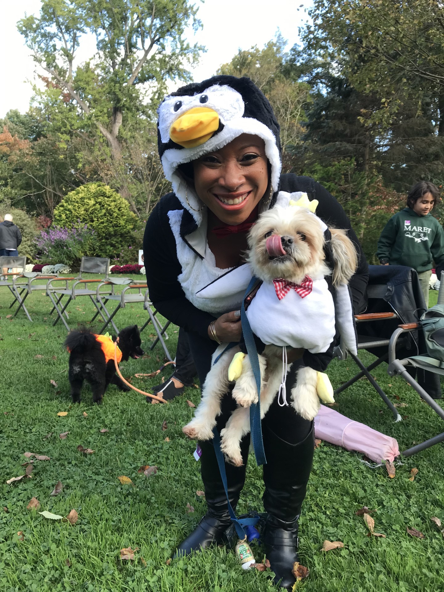 Woman holding dog, both in costume